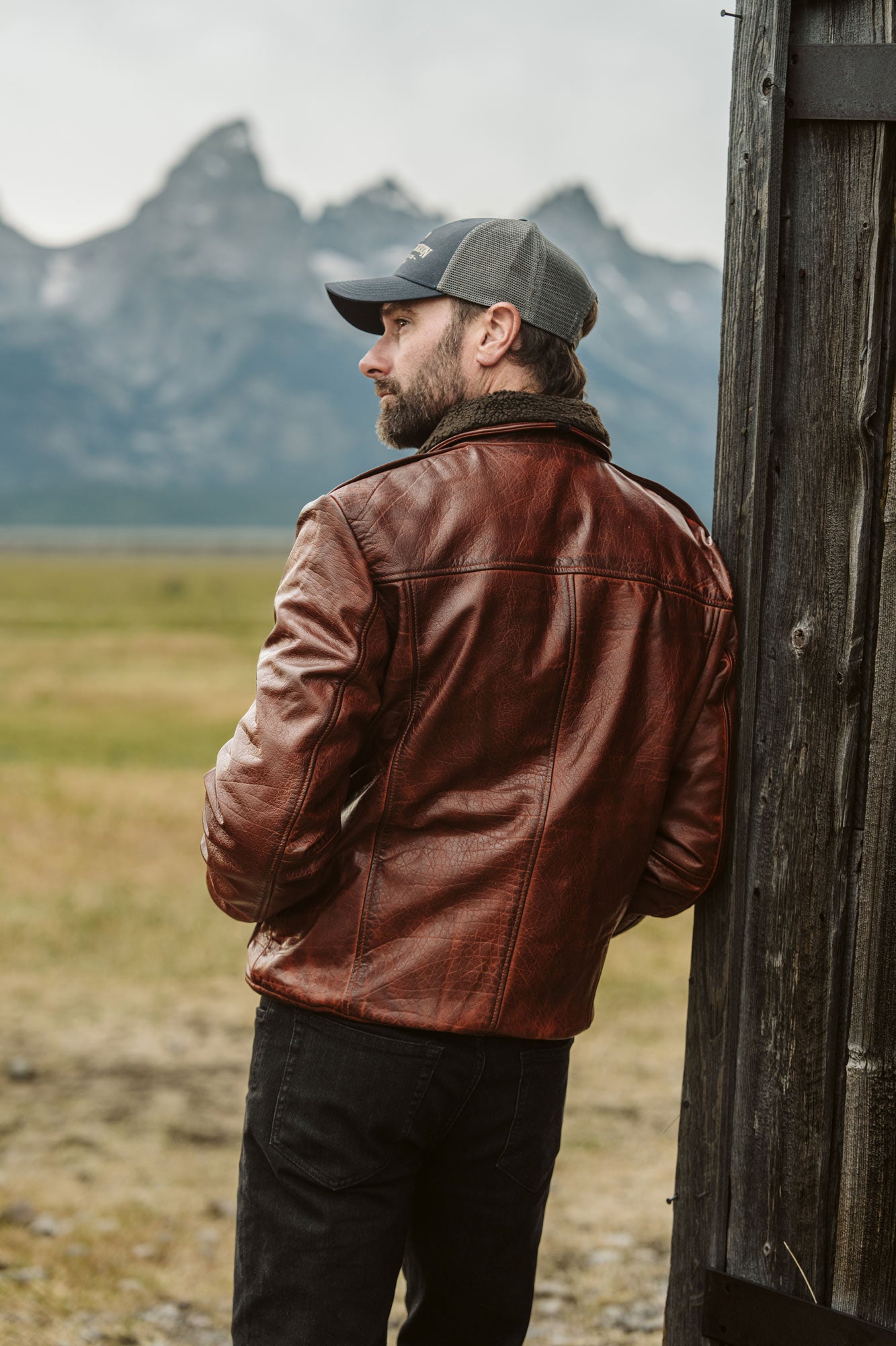 Side profile of man in Maverick Buffalo Grain Brown leather bomber jacket showing ribbed cuff and waistband details.