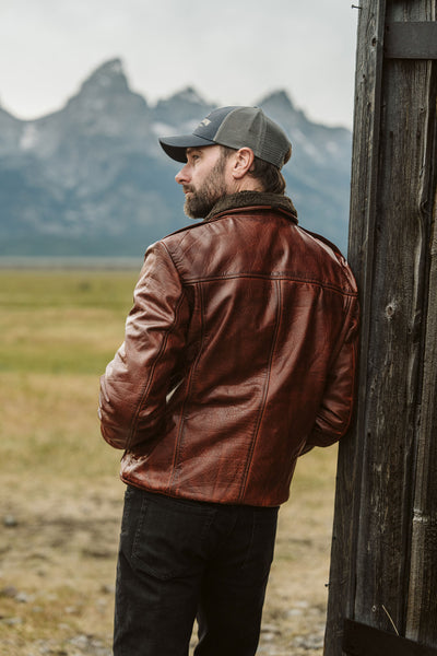 Side profile of man in Maverick Buffalo Grain Brown leather bomber jacket showing ribbed cuff and waistband details.