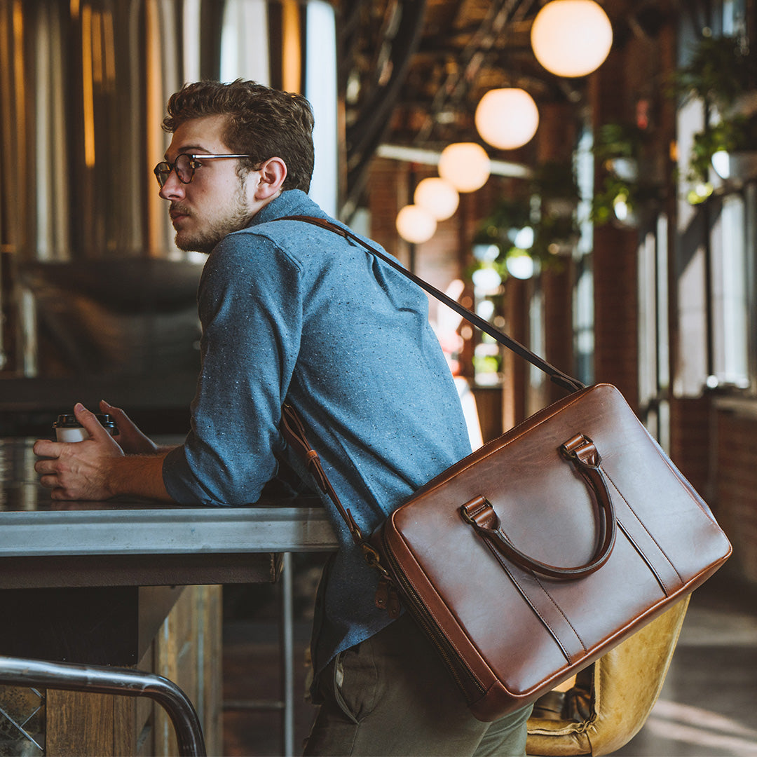 Stylish tan leather briefcase, seamlessly matching business attire, with elegant lines and polished hardware for a sophisticated look.