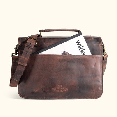 Durable dark oak leather briefcase with adjustable strap and traditional buckle closures, ideal for office or travel.