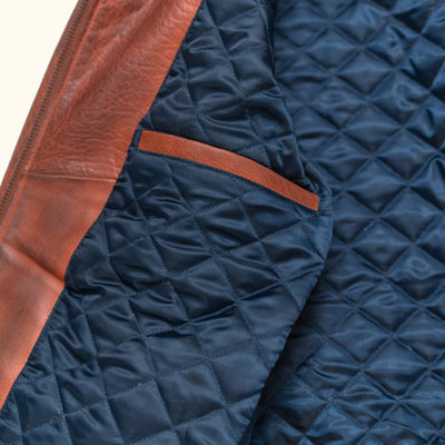 Interior of Maverick bomber jacket showing quilted navy nylon lining and YKK zippered interior chest pocket.