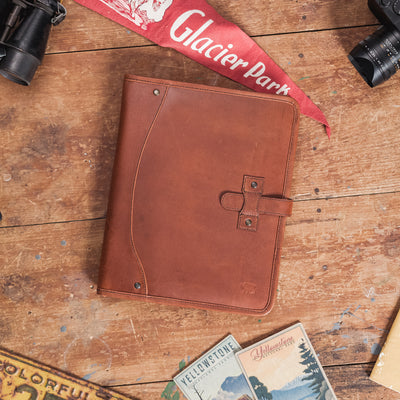 Dark oak Roosevelt leather travel padfolio, elegantly designed with a secure strap closure and fine stitching for a polished look.