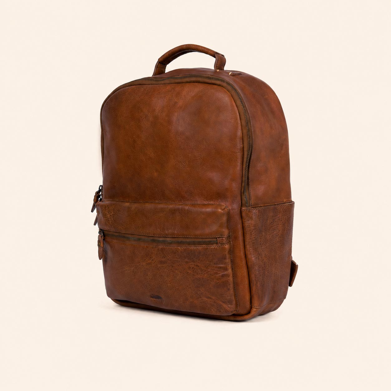 Brown leather backpack on a beige background