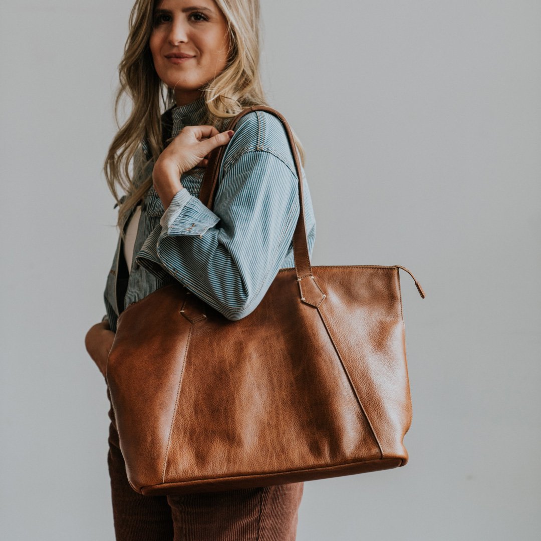 Woman carrying the Walker rustic tan leather tote on her shoulder