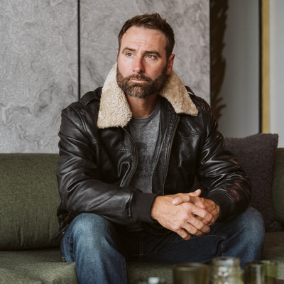 Men's black leather bomber jacket from Buffalo Jackson, front view on model, soft lambskin with detachable sherpa collar attached