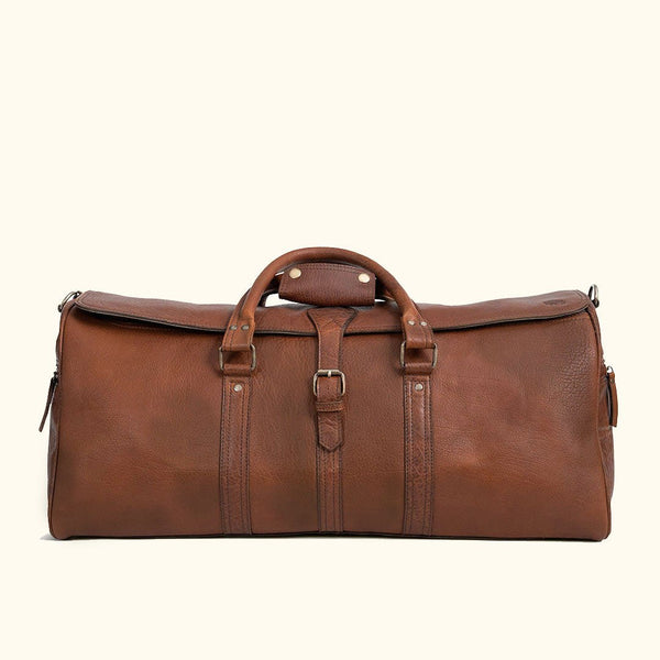 Roosevelt full-grain buffalo leather travel duffle bag in brown with brass buckles and adjustable shoulder strap, an heirloom third anniversary gift for him
