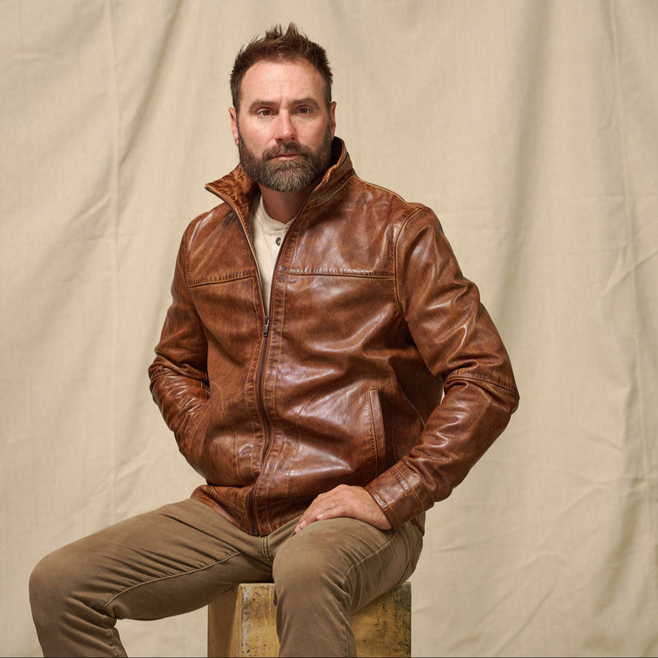 The Sedona Lightweight Leather Jacket in Copperwood Brown — full portrait, zipped, hands in pockets, direct gaze