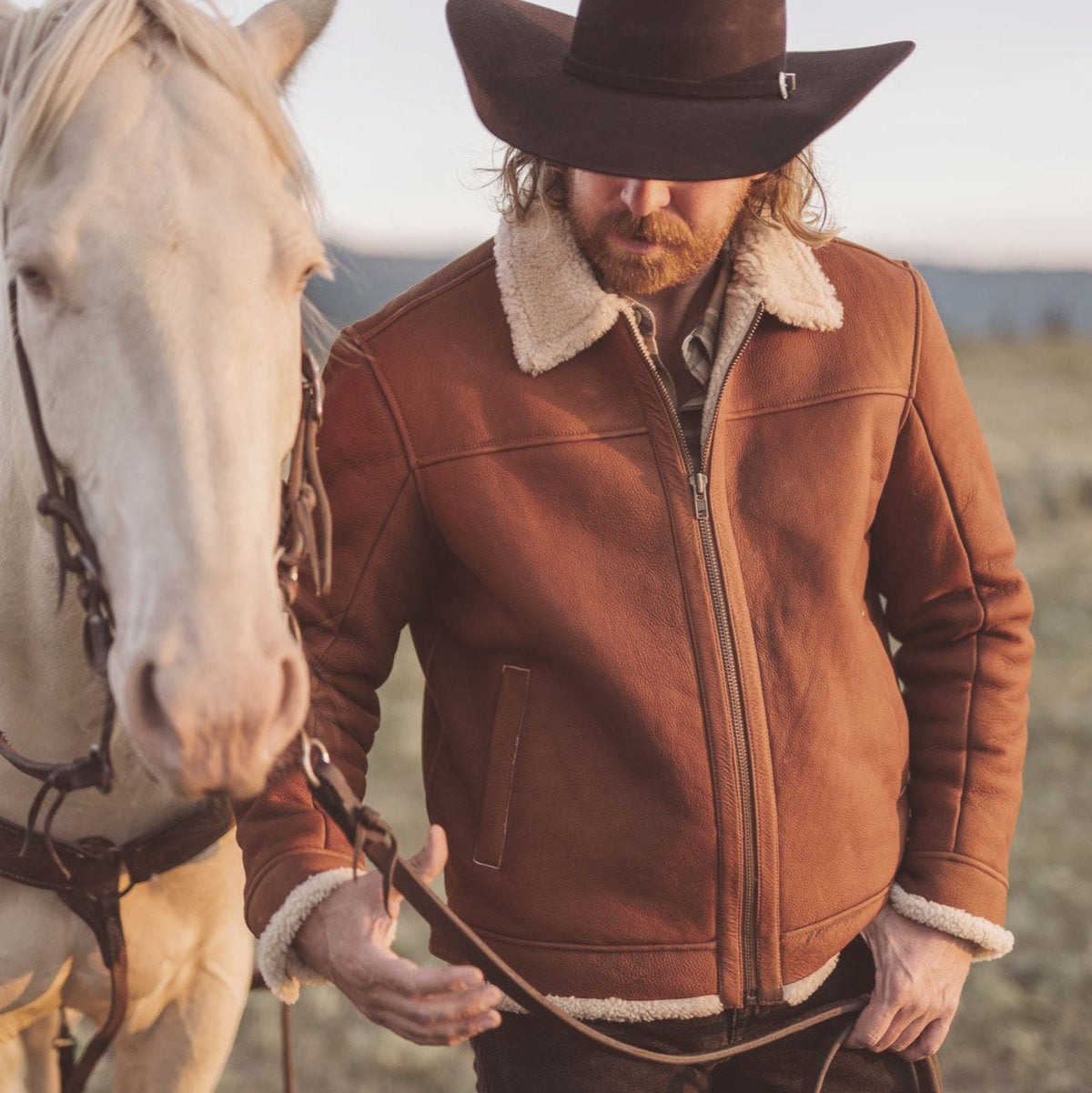 Man wearing a whiskey brown shearling leather bomber jacket outdoors in winter