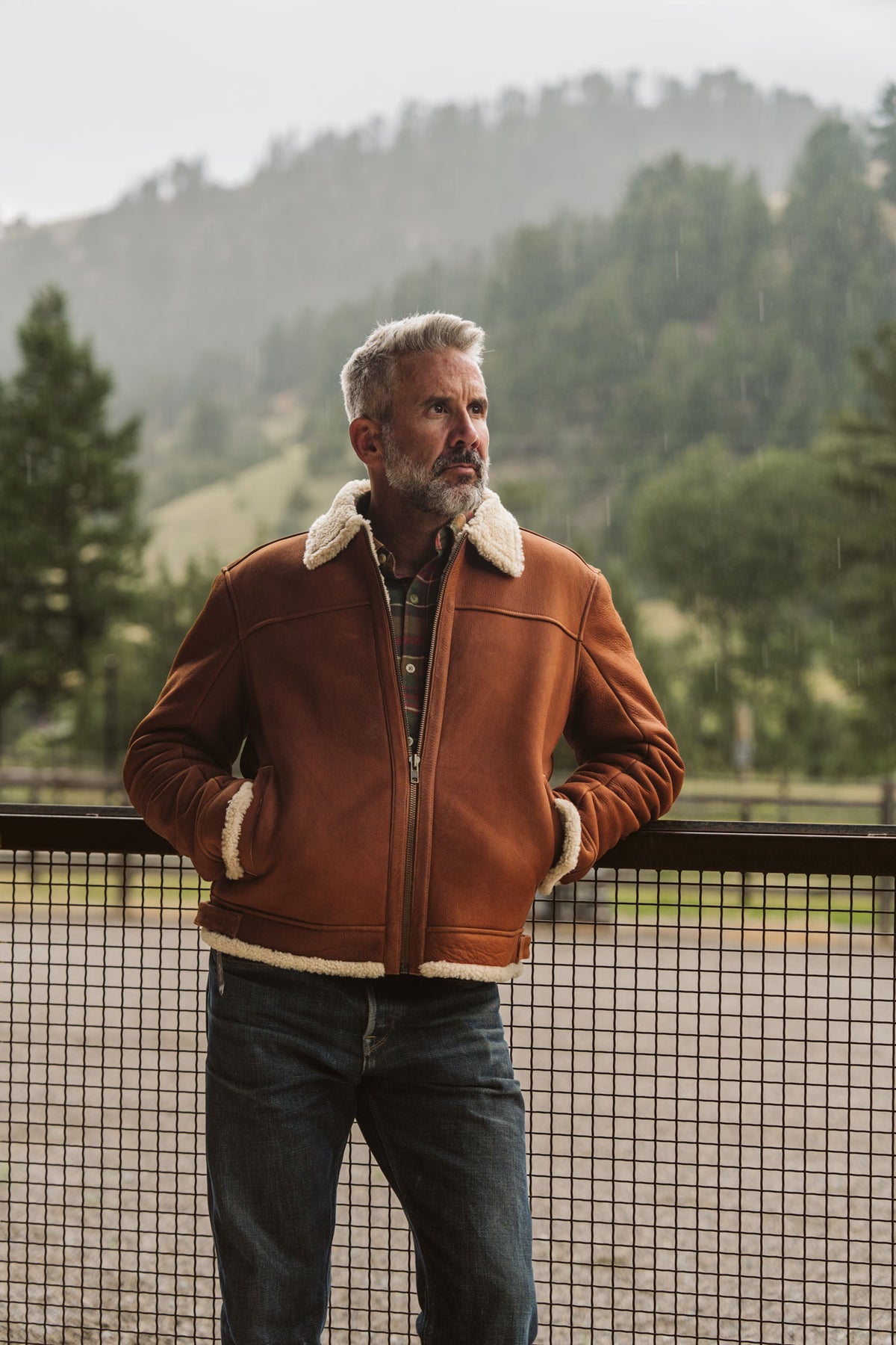 Man wearing a whiskey brown shearling leather bomber jacket in winter