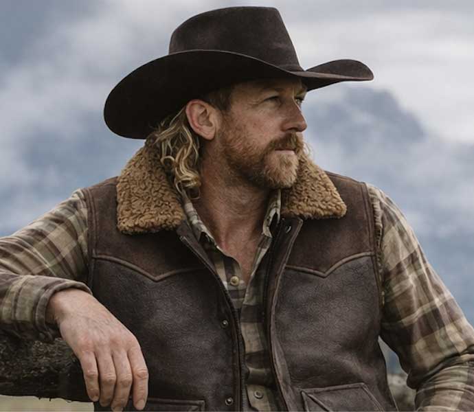 Man wearing a two-tone western shearling leather vest over a shirt