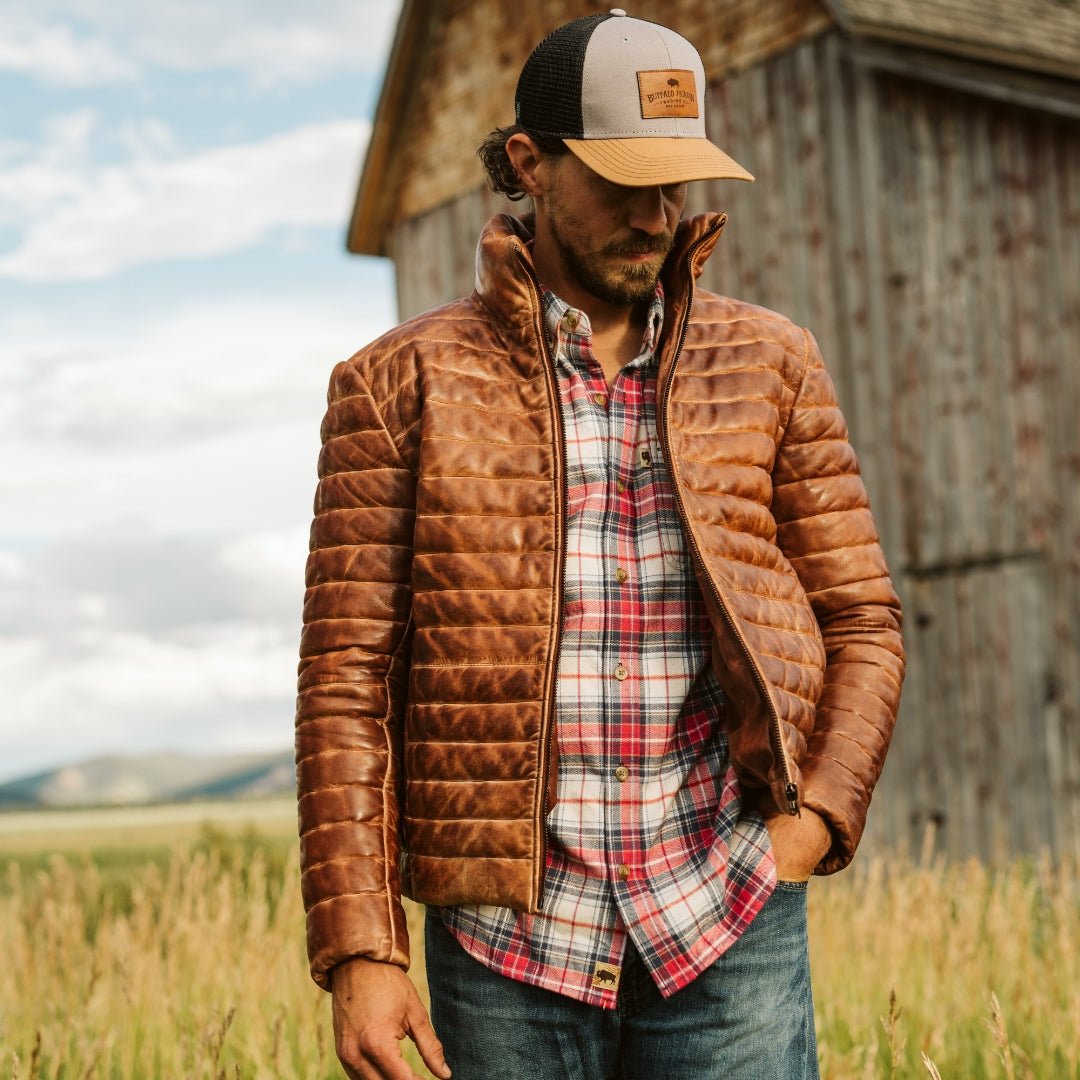 Man wearing the Bridger Leather Down Jacket in Light Brown on a cold morning out west