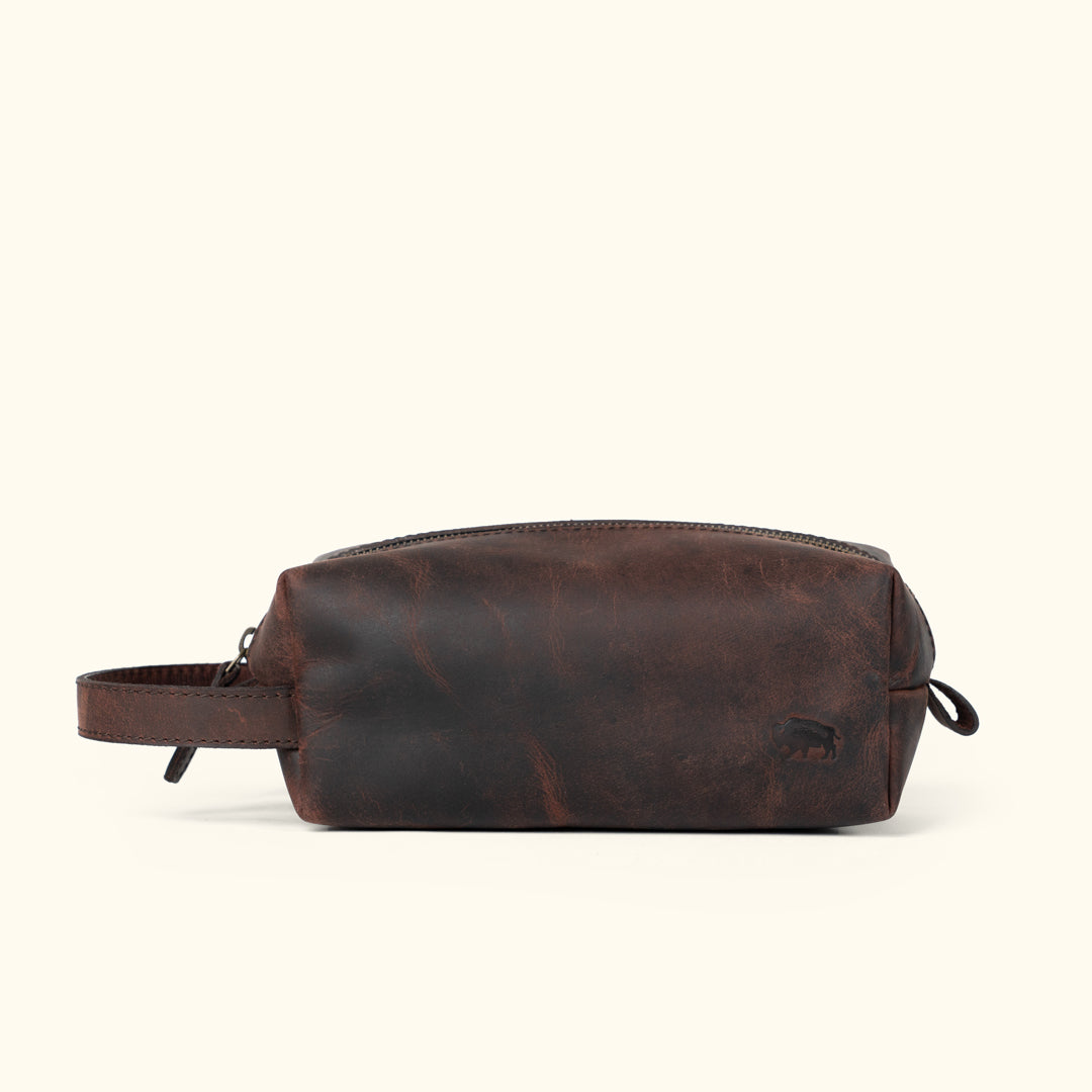 Sleek Roosevelt travel toiletry bag in dark oak leather with a minimalist, functional design.