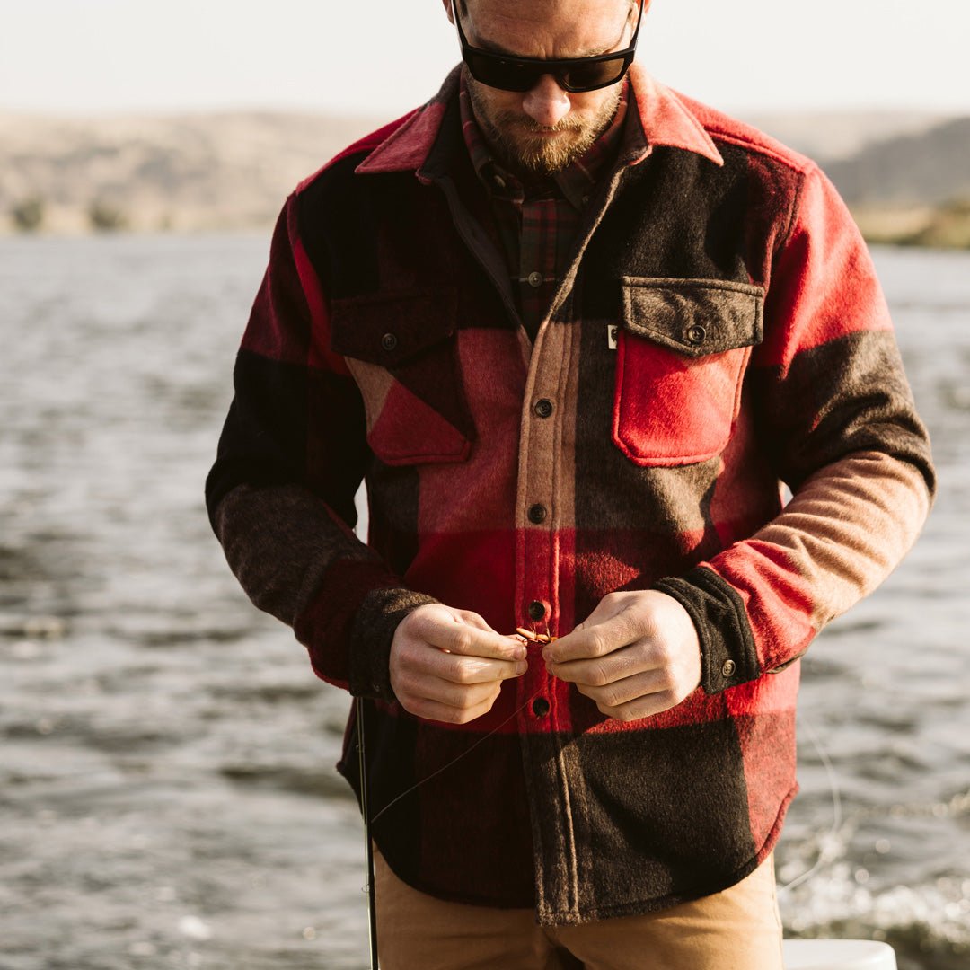 Man by the water wearing the Yukon Wool Shirt Jac in Red Valley Plaid