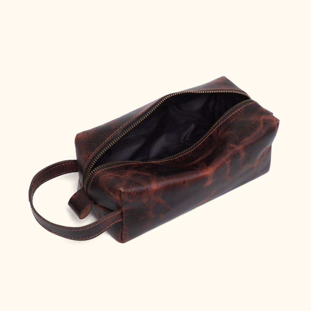 Dark oak Roosevelt buffalo leather dopp kit with durable wrist strap and embossed buffalo logo.
